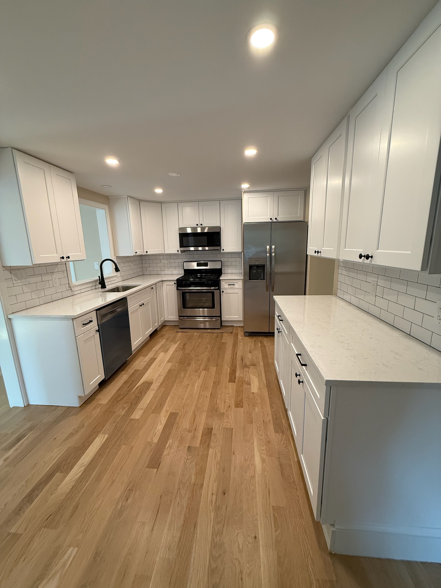 Kitchen renovation — white shaker cabinets, quartz countertops, and subway tile