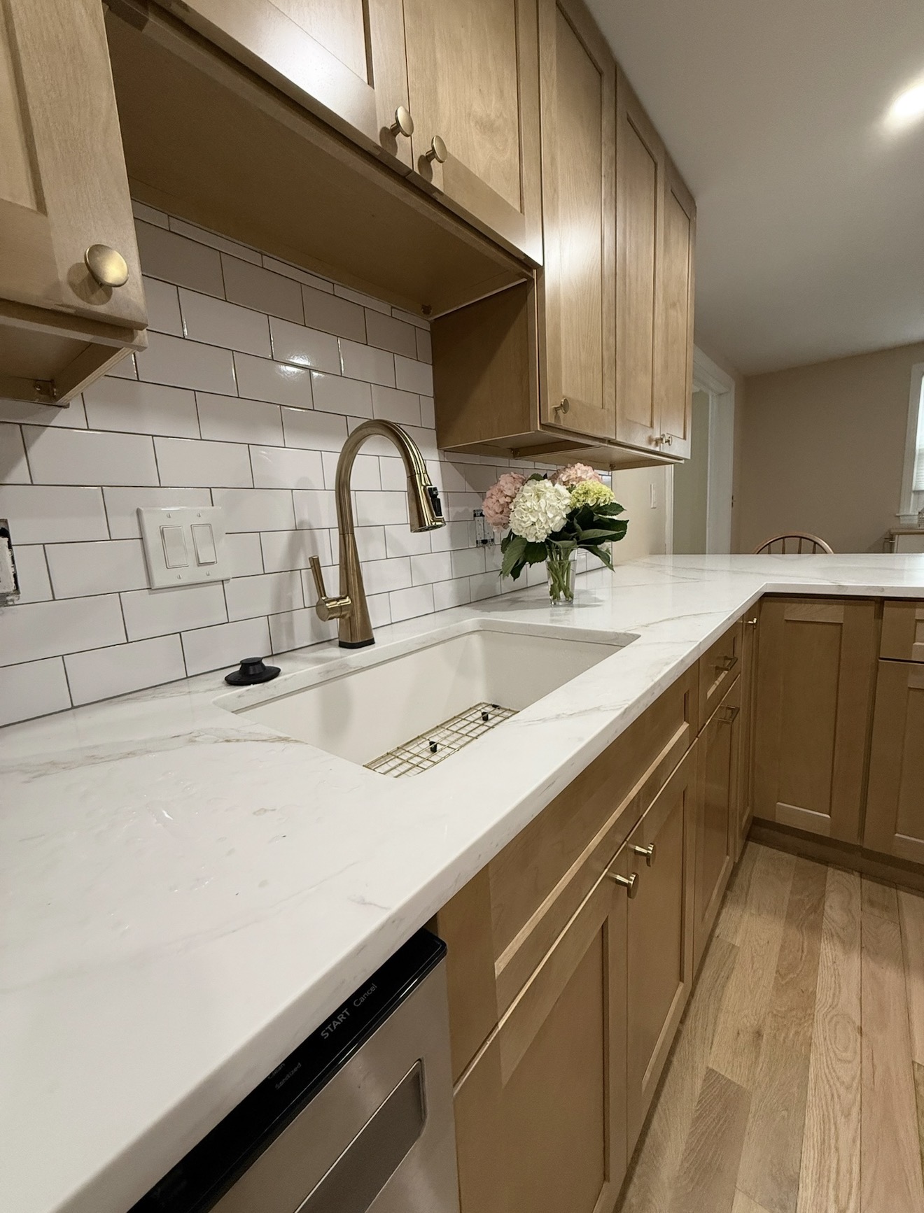 Kitchen renovation — quartz countertops, subway tile backsplash, and brass fixtures