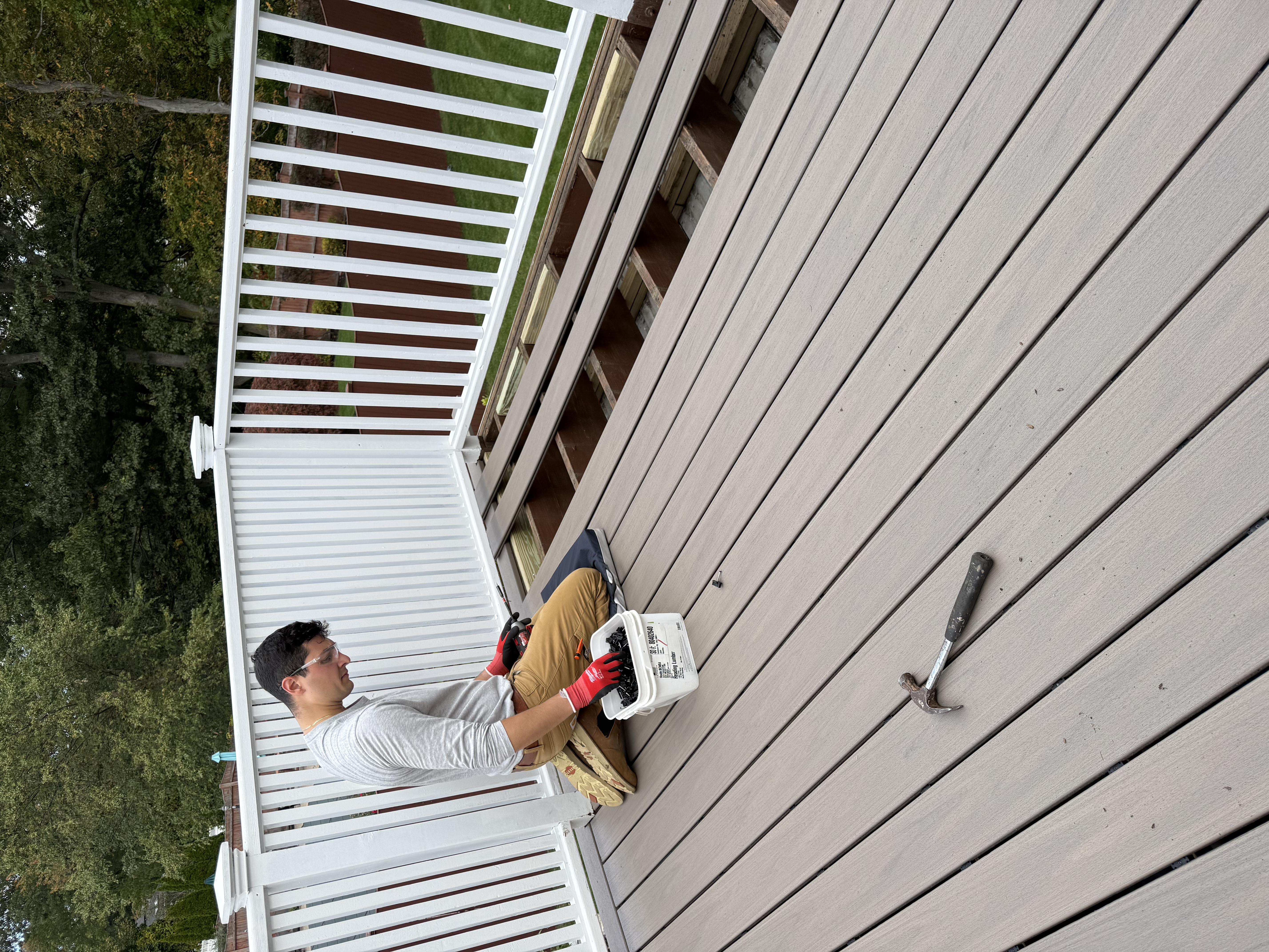 Composite deck build — installing decking boards with white railing